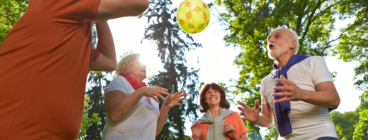 Gruppe von älteren Menschen spielt mit Ball